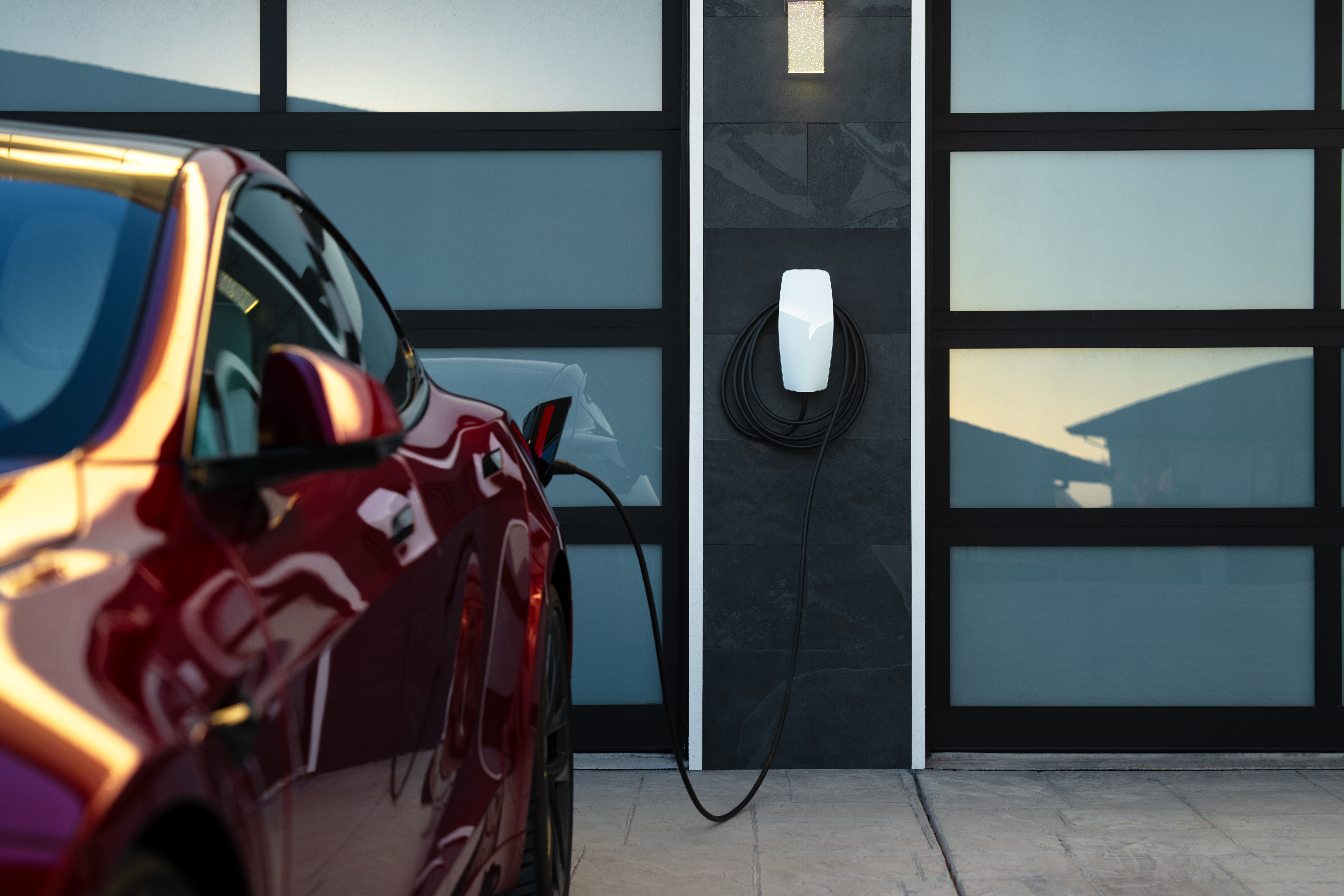 Tesla Wall Connector in modern garage with red Tesla charging